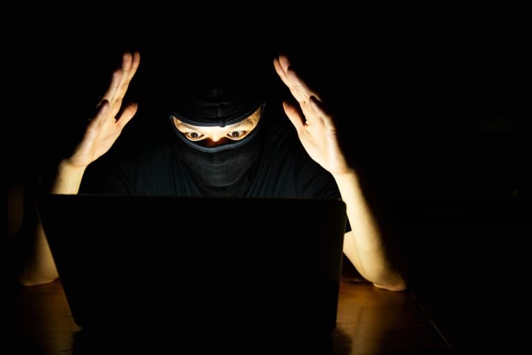 computer hacker doing his job with laptop computer dark room 1150 14568